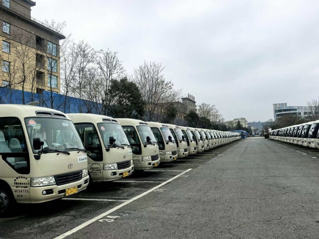 Inventory of 45 used Toyota Coaster mini-buses for export, lined up at China's Nansha Port terminal, ready for international delivery.